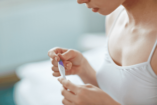 woman and pregnancy test surviving the two week wait